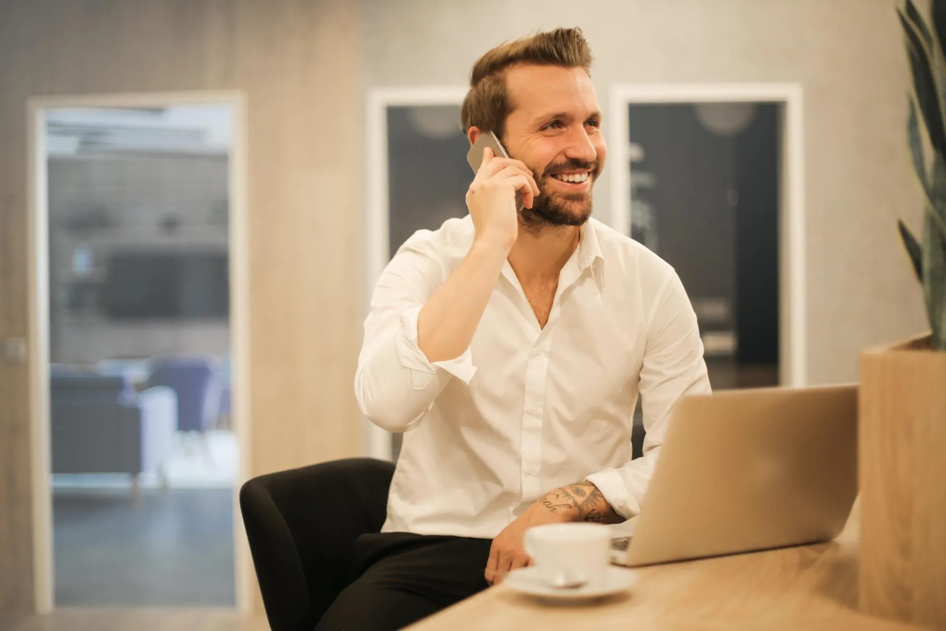 Professionals smiling making a call in a cafe