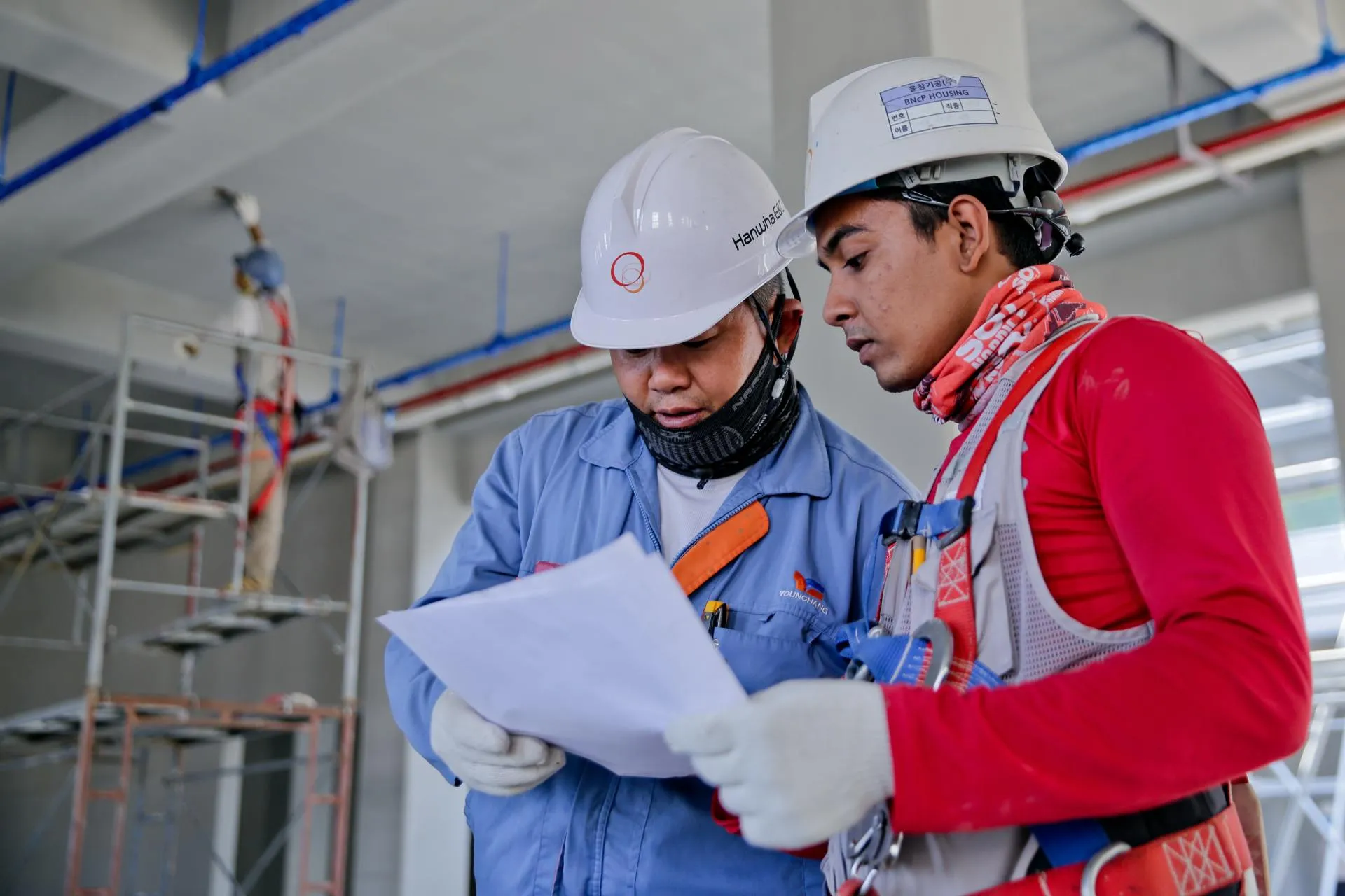 two construction workers on site reviewing documents