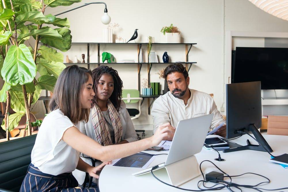 coworkers looking at a laptop together