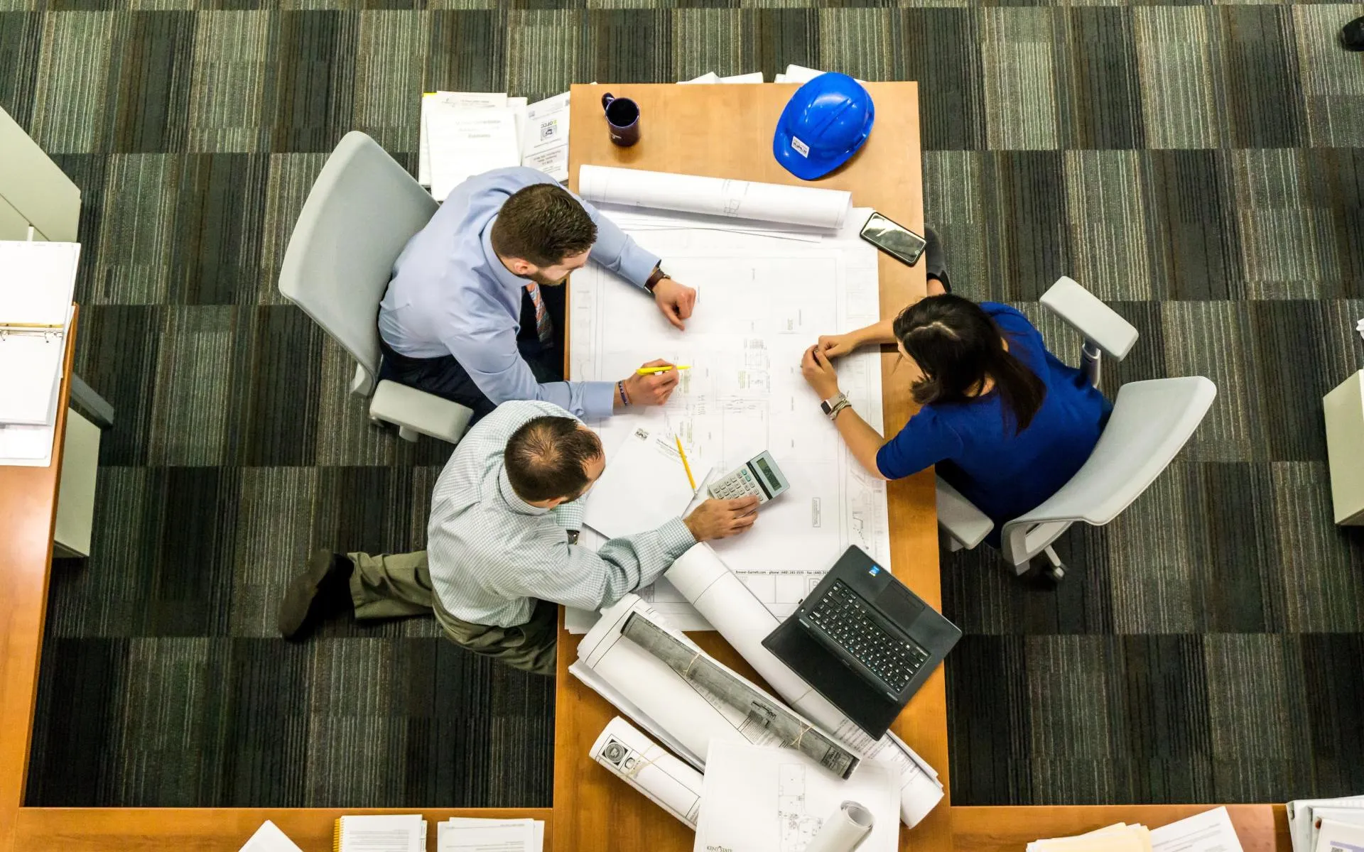 engineers reviewing blueprints in a meeting