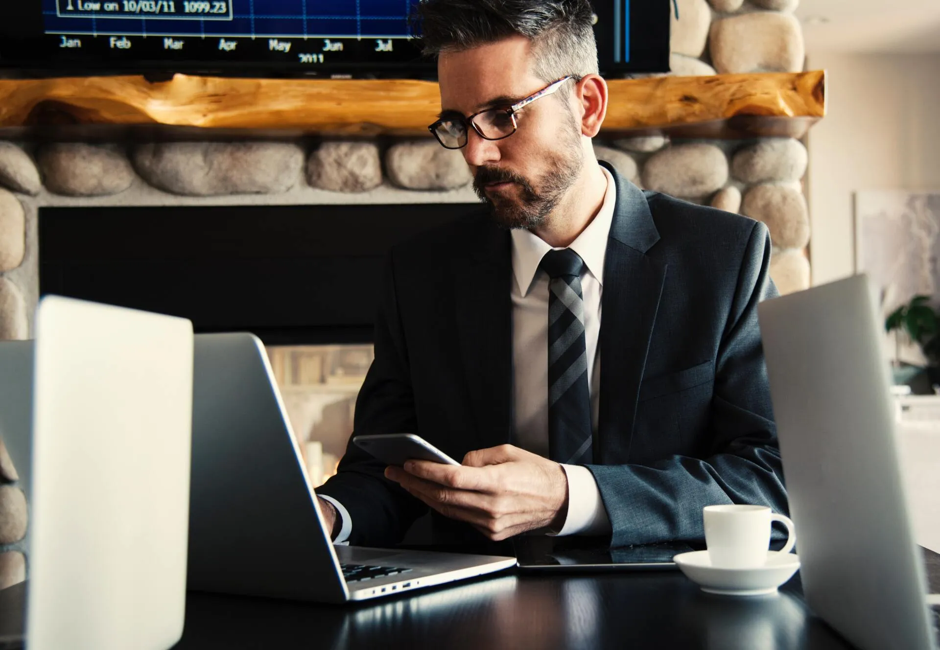 Professional using his phone and laptop in a cafe