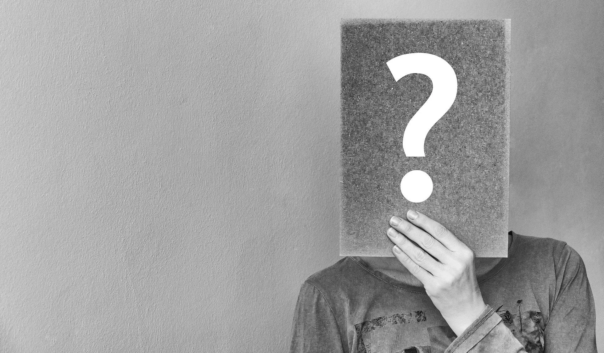 person with a question mark covering their face
