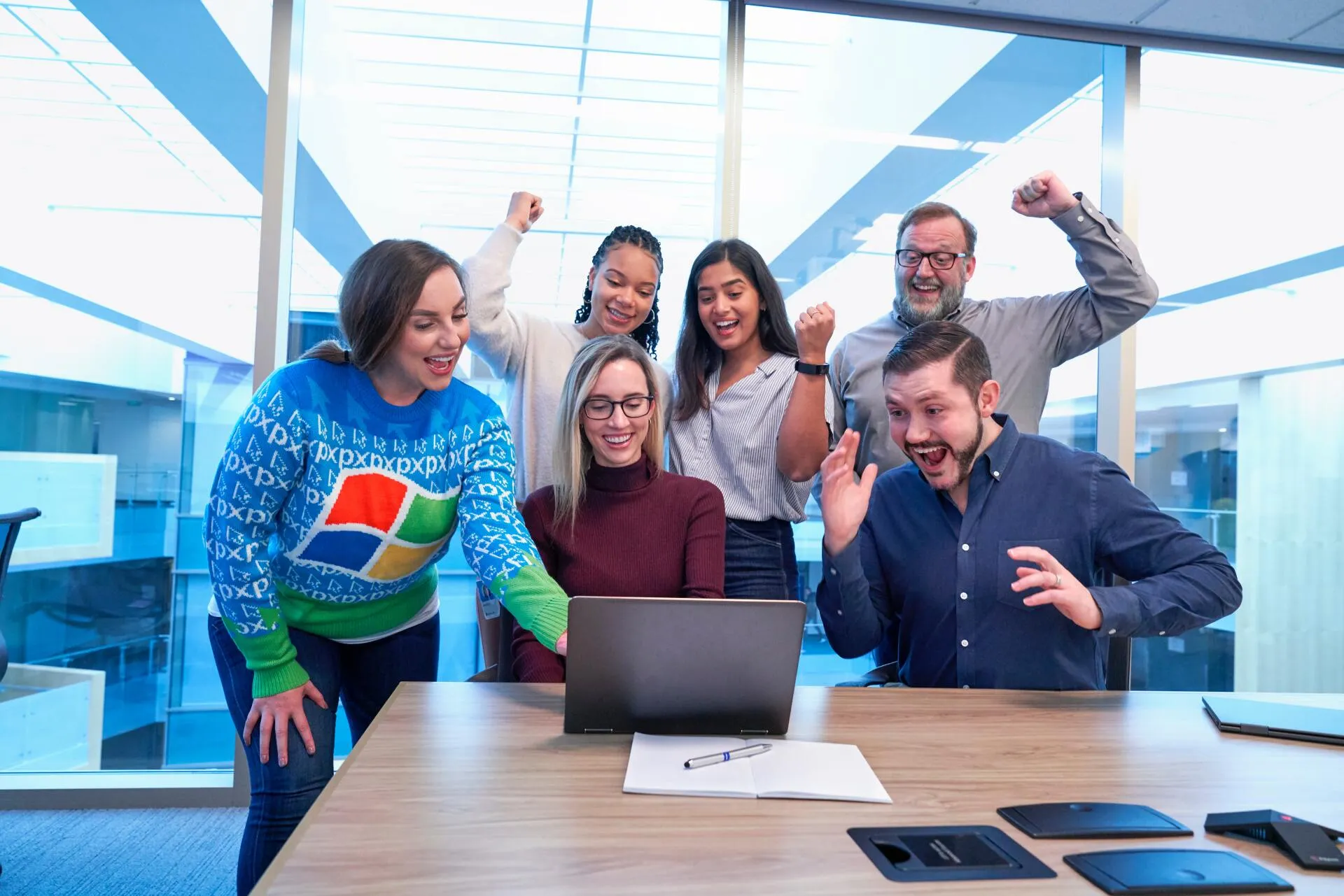 professionals celebrating around laptop