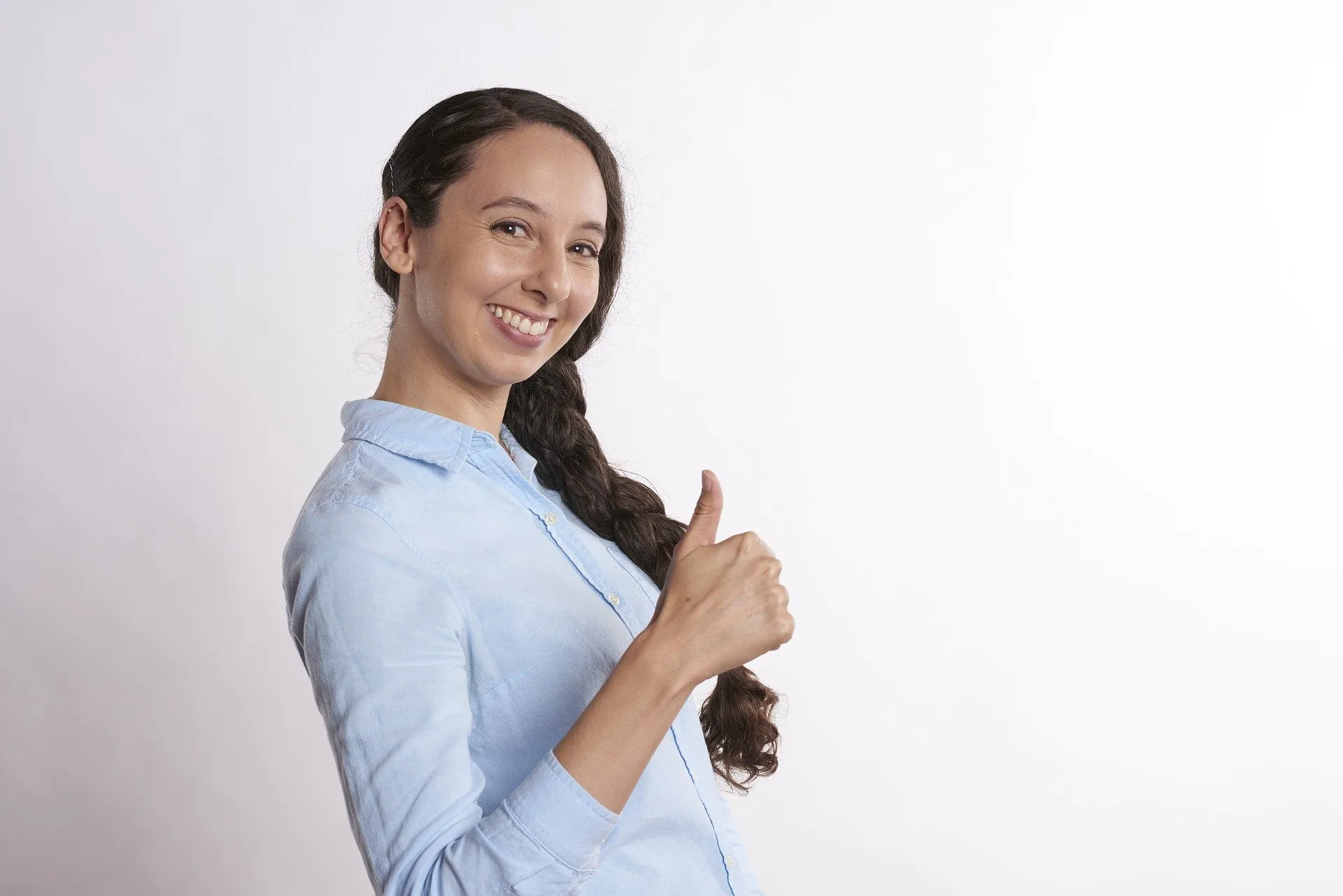 smiling young woman giving a thumbs up to the camera